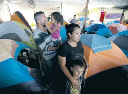  ?? Photograph­s by Nelvin C. Cepeda San Diego Union-Tribune ?? GUSTAVO LOZA and his wife, Leidy Rivas, arrived in Tijuana with their two kids after traveling more than a month from El Salvador.