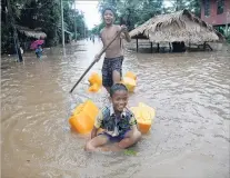  ?? PHOTO: REUTERS ?? Waterway . . . Boys play in a flooded street in Kyaikto township, in Mon state, Myanmar.