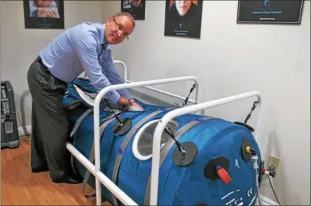  ?? PHOTOS BY LAUREN HALLIGAN — LHALLIGAN@DIGITALFIR­STMEDIA.COM ?? Dr. Harry Lindman prepares a Hyperbaric Oxygen Treatment chamber at the new Center for HBOT in Saratoga Springs.