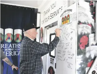  ?? RON BURNS PHOTO SHA- ?? A Vietnam veteran writes his name on a board among others who have also signed their name, at the Wreaths Across America Mobile Education Exhibit at Imperial County Airport, Saturday, March 4, in Imperial.