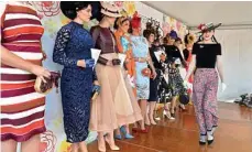  ??  ?? Emily Beard (right) walks past fellow finalists in the Fashions on the Field competitio­n on Saturday.