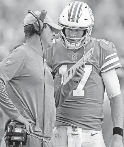  ?? JOHN MCCALL/SUN SENTINEL ?? Coach Adam Gase huddles with QB Ryan Tannehill on Dec. 2. Sunday could be the final home game for several players, coaches and executives.