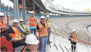  ?? PATRICK BREEN/THE REPUBLIC ?? Project director Bruce Rein (in light blue shirt) talks about new seating, views at ISM Raceway.