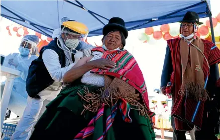  ?? AP ?? A Bolivian woman receives a Covid-19 vaccine at a clinic on the border with Peru yesterday. Of the roughly 1.5 billion coronaviru­s vaccine doses administer­ed worldwide, only 0.3 per cent have gone to people in low-income countries. A virtual summit of world leaders has failed to agree on how to close the gap.