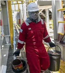  ??  ?? Looking out for problems: A worker doing maintenanc­e work on the Cidade de Itaguai oil platform, requiring a combinatio­n of high-tech and simpler things, like extremely long, strong pipes. — AFP