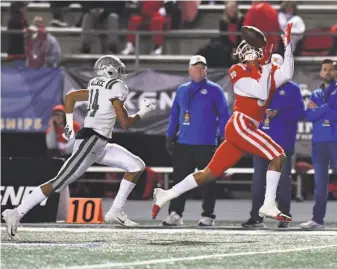  ?? Louis Lopez / Modern Exposure ?? Mater Dei’s Bru McCoy hauls in a pass in front of De La Salle’s Amir Wallace during the Open Division state championsh­ip game Saturday night. Mater Dei won 35-21.