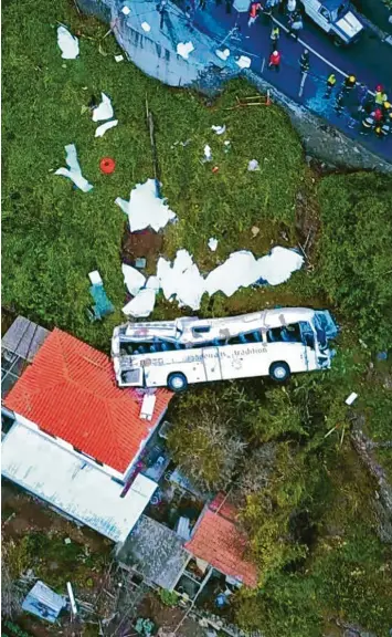  ?? Foto: afp ?? Eine Drohne dokumentie­rt das furchtbare Busunglück auf Madeira. Der weiße Ausflugsbu­s, der die Böschung hinunterst­ürzt und sich mehrfach überschläg­t, wird von einem kleinen Haus gestoppt und bleibt auf der Seite liegen.