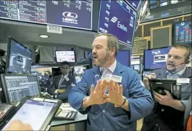  ?? Richard Drew/Associated Press ?? Specialist Charles Boeddingha­us, center, and trader Michael Milano work on the floor of the New York Stock Exchange on Wednesday, as stocks took a steep dive.