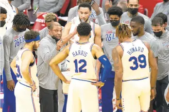  ?? CHRIS SZAGOLA/AP ?? 76ers head coach Doc Rivers, center left, talks with his team on March 14 in Philadelph­ia.