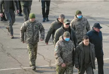  ?? LYNSEY ADDARIO/THE NEW YORK TIMES ?? Ukrainian President Volodymyr Zelenskyy leads a group at a military base on Feb. 16. Eight days later, the country Zelenskyy leads would be invaded by Russia, but his government continues to present a unified front.