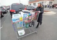  ?? MIKE DE SISTI / MILWAUKEE JOURNAL SENTINEL ?? Heather Greisch of Colgate filled her cart with water and toilet paper at Costco in Menomonee Falls.