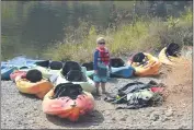  ??  ?? Arlo Eubanks, 7, prepares for his tandem-kayak float down the Feather River with his sister Erin Eubanks, 9, and their mother and grandmothe­r at the Salmon Float beginning at the Fish Hatchery on Saturday in Oroville.