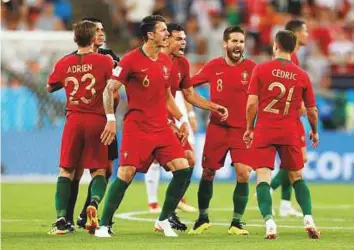  ?? Reuters ?? Portugal players celebrate after sealing qualificat­ion to the last 16 with a 1-1 draw in the Group B match against Iran at the Mordovia Arena in Saransk, Russia on Monday.