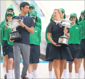  ??  ?? TOPS DOWN UNDER: Current Australian Open tennis champions, Serbia’s Novak Djokovic and Germany’s Angelique Kerber, parade the trophies ahead of the official draw in Melbourne.