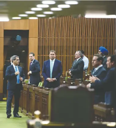  ?? JUSTIN TANG / THE CANADIAN PRESS ?? Conservati­ve MPs, including leader Andrew Scheer, wait for the Speaker’s parade to arrive, as a limited number of
MPs returned to the House of Commons on Tuesday to discuss measures to respond to the COVID-19 outbreak.