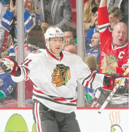  ??  ?? Marian Hossa waits for the celebratio­n to start after scoring the winning goal in overtime Saturday against the Canucks. | GETTY IMAGES