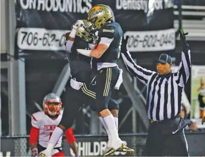  ?? STAFF PHOTO BY DOUG STRICKLAND ?? Calhoun’s Bralin Barton, left, celebrates a touchdown with teammate Logan Parker during the Yellow Jackets’ 24-12 GHSA Class AAA quarterfin­al win over visiting Jenkins on Friday Night at Phil Reeve Stadium.