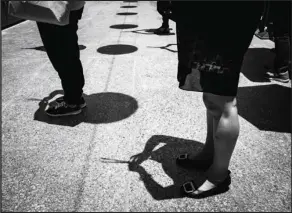  ?? INSTAGRAM @BRIANLHY_ / ?? People pray while holding incense sticks in the hot summer sun around noon at Wong Tai Sin Temple in Kowloon.