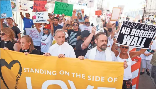  ?? PATRICK BREEN/THE REPUBLIC ?? Rev. Matthew Clary and protesters rally at the DeConcini port of entry during the Families Belong Together march in Nogales on Saturday.