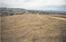  ?? Brian Feulner / Special to The Chronicle ?? Sugarloaf Hill in San Mateo is parched, without even a blade of green visible. But weather watchers aren’t ready to panic.