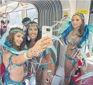  ??  ?? Chloe Azimian, left, takes a selfie with Lindsay Govin aboard a streetcar en route to the parade.