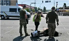  ?? Photograph: Sergei Supinsky/AFP/Getty Images ?? Police experts examine fragments of a missile from an unusual daytime attack targeting the Ukrainian capital on Monday.