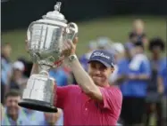  ?? CHRIS O’MEARA — THE ASSOCIATED PRESS ?? Justin Thomas poses with the Wanamaker Trophy after winning the PGA Championsh­ip golf tournament at the Quail Hollow Club Sunday in Charlotte, N.C.