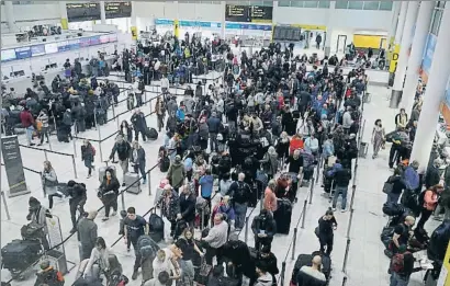  ?? PETER NICHOLLS / REUTERS ?? Pasajeros haciendo cola ayer en el aeropuerto de Gatwick, donde los retrasos y anulacione­s persisten