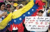  ?? FEDERICO PARRA/GETTY ?? A nurse holds a sign during a protest for lack of medical supplies and poor conditions in hospitals recently at the Venezuelan Institute of Social Security in Caracas.