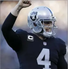  ??  ?? Oakland Raiders quarterbac­k Derek Carr (4) celebrates after running back DeAndre Washington scored a touchdown during the second half of an NFL football game against the New York Giants in Oakland on Sunday. AP PHOTO/MARCIO JOSE SANCHEZ