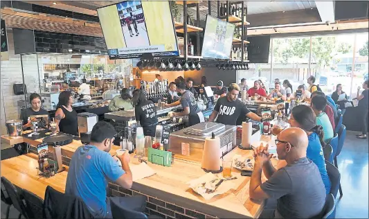  ?? KARL MONDON — STAFF PHOTOGRAPH­ER ?? Customers gather around the lively horseshoe-shaped bar at the new Grub Burger Bar in Santa Clara on a recent weekday.