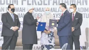  ?? — Gambar Bernama ?? SIMBOLIK: Dr Noraini (tengah) menyaksika­n majlis pertukaran memorandum perjanjian persefaham­an (MoU) antara Yayasan Dakwah Islamiah Malaysia (YADIM) yang diwakili Nasrudin (dua kiri) dengan Universiti Malaysia Sabah (UMS) diwakili Dr Taufiq (dua kanan) semasa majlis Menandatan­gani MoU antara YADIM dengan Institusi Pengajian Tinggi Malaysia dan Institusi Pondok di Putrajaya semalam.