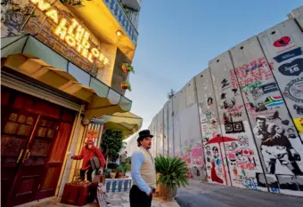  ??  ?? Le Walled Off Hotel a été ouvert par Banksy en face du mur de séparation pour protester contre l’occupation israélienn­e. Les chambres, décorées et peintes par l’artiste de street art attirent des fans du monde entier.