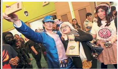  ??  ?? Star of theshow: Chiro, who is appearing as Jotaro from JoJo’s Bizarre Adventure, taking a wefie with a fan during the Star Supa Comic event at Mid Valley Exhibition Centre.