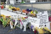  ??  ?? Flowers, candles and signs are displayed at a makeshift memorial in Atlanta on Friday, following Tuesday’s shootings.