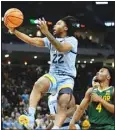  ?? ?? Marquette’s Sean Jones shoots past Baylor’s LJ Cryer during the first half of an NCAA basketball game in Milwaukee. (AP)