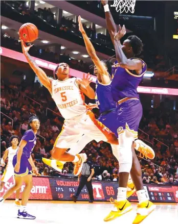  ?? AP PHOTO/WADE PAYNE ?? Tennessee guard Zakai Zeigler (5) shoots over Tennessee Tech’s Mamoudou Diarra, right, and Jr. Clay during Friday’s game at Thompson-Boling Arena. Clay, a McCallie graduate, scored a game-high 19 points.