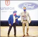  ??  ?? Unifor President Jerry Dias, (left), elbow bumps Ryan Kantautas, Vice-President of Human Resources at Ford Canada, after a photo opportunit­y at the start of formal contract talks with the Detroit Three automakers, Fiat Chrysler, Ford and General Motors, in Toronto, on Aug 12, 2020. (AP)