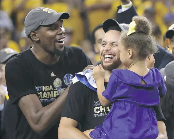  ?? EZRA SHAW/GETTY IMAGES ?? Golden State Warriors teammates Kevin Durant, left, and Stephen Curry celebrate after winning the NBA Finals on Monday night in Oakland, Calif.