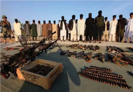  ?? EPA PIC ?? Pakistani security officials showing suspected militants with seized weapons in the Khyber Agency on Thursday.