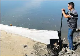  ?? THE CANADIAN PRESS/ FILES ?? Chief Wally Burns of the James Smith Cree Nation surveys the North Saskatchew­an River next to an oil boom set up following a spill from a Husky pipeline in July.