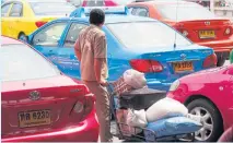  ?? PATTANAPON­G HIRUNARD ?? A passenger waits in line to grab a taxi at Mo Chit bus station in this file photo.