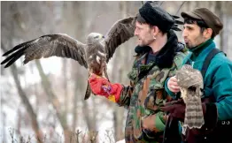  ?? — AFP ?? Men carry birds of prey during bird day celebratio­ns in a park in Moscow on Sunday. This day marks the first return of migratory birds from their wintering sites.