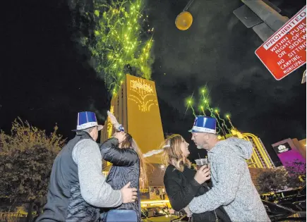  ?? L.E. Baskow Las Vegas Review-journal @Left_eye_images ?? Fireworks erupt over the south tower of the Plaza at the start of the new year just after midnight Thursday in Las Vegas. From left, Adam Overcast, Maddie, Allison and Jeff Knutsen of Seattle.