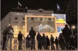  ?? — AFP ?? People watch “Zeituhr 1938”, a projection on the facade of the Austrian chanceller­y that retraces the dark moments leading to the Nazi takeover by Adolf Hitler in 1938, one day ahead of the 80th anniversar­y of Austria’s annexation ( Anschluss), on March 11 in Vienna.