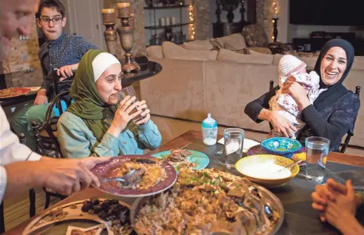  ?? THOMAS HAWTHORNE/THE REPUBLIC ?? From left, Akram, Mohammad, Seham and Salmah Monsour, with daughter Misk, enjoy a Palestinia­n meal at home.