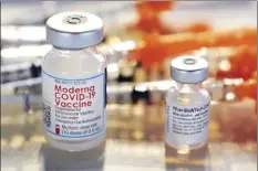  ?? AP file photo ?? Vials for the Moderna and Pfizer COVID-19 vaccines at a temporary clinic in Exeter, N.H. on Feb. 25. In September, the Food and Drug Administra­tion approved extra doses of Pfizer’s original COVID-19 vaccine after studies showed it still works well enough against the delta variant. And the FDA is weighing evidence for boosters of the original Moderna and Johnson & Johnson vaccines.