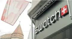  ?? ?? The Swiss flag and a logo of Swiss watchmaker Swatch are seen outside a shop in Zurich. REUTERS