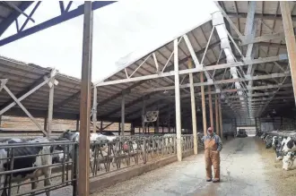  ?? JIM MATTHEWS/USA TODAY NETWORK-WISCONSIN ?? Gary Olson of Synergy Dairy near Pulaski shows the damage heavy weekend snow caused to one of the barns after more than 2 feet of snow fell.