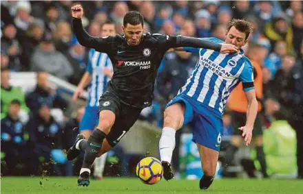  ?? REUTERS PIC ?? Chelsea's Eden Hazard (left) tries to dribble past Brighton’s Dale Stephens in a Premier League match at The American Express Community Stadium in Brighton, on Saturday.